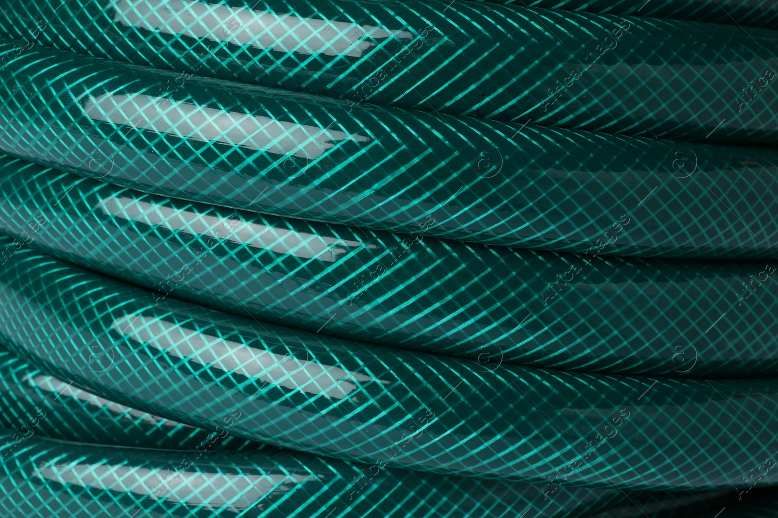 Photo of Green rubber watering hose as background, closeup