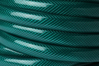 Green rubber watering hose as background, closeup