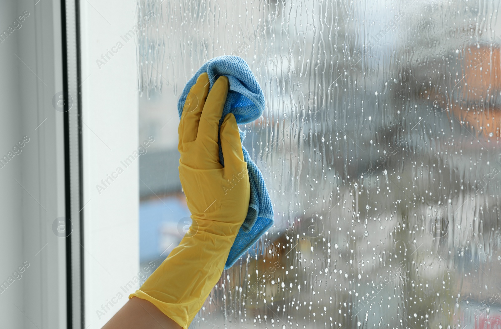 Photo of Woman cleaning window at home, closeup view