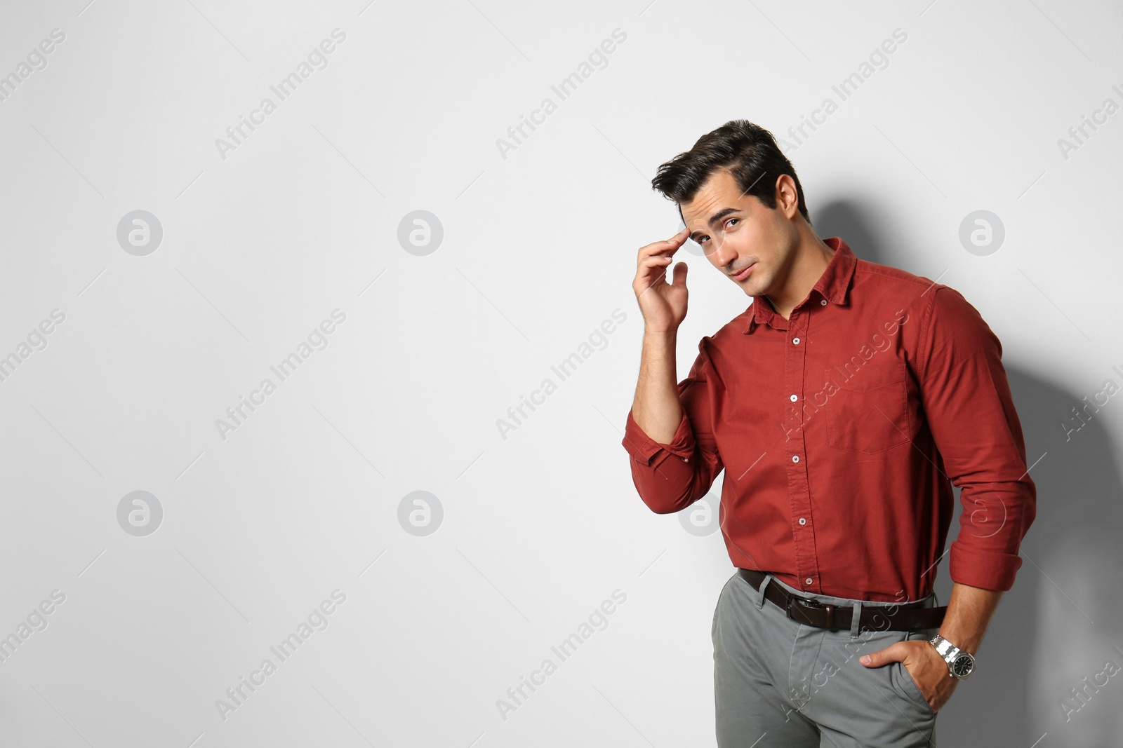 Photo of Handsome young man in stylish clothes on light beige background. Space for text