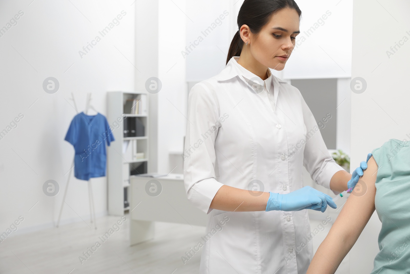 Photo of Doctor giving hepatitis vaccine to patient in clinic. Space for text