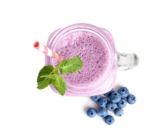 Photo of Tasty blueberry smoothie in mason jar on white background, top view