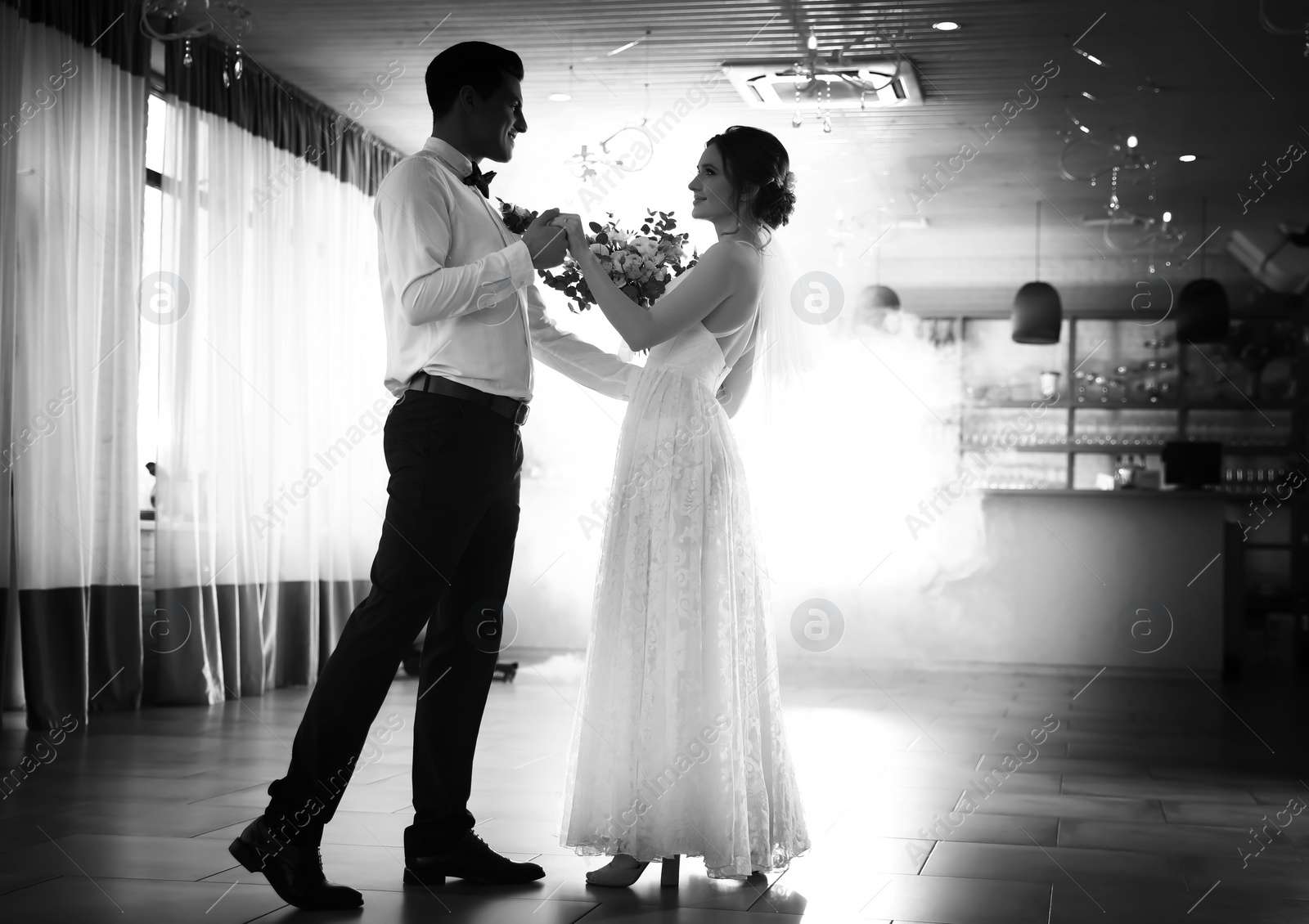 Image of Happy newlywed couple dancing together in festive hall