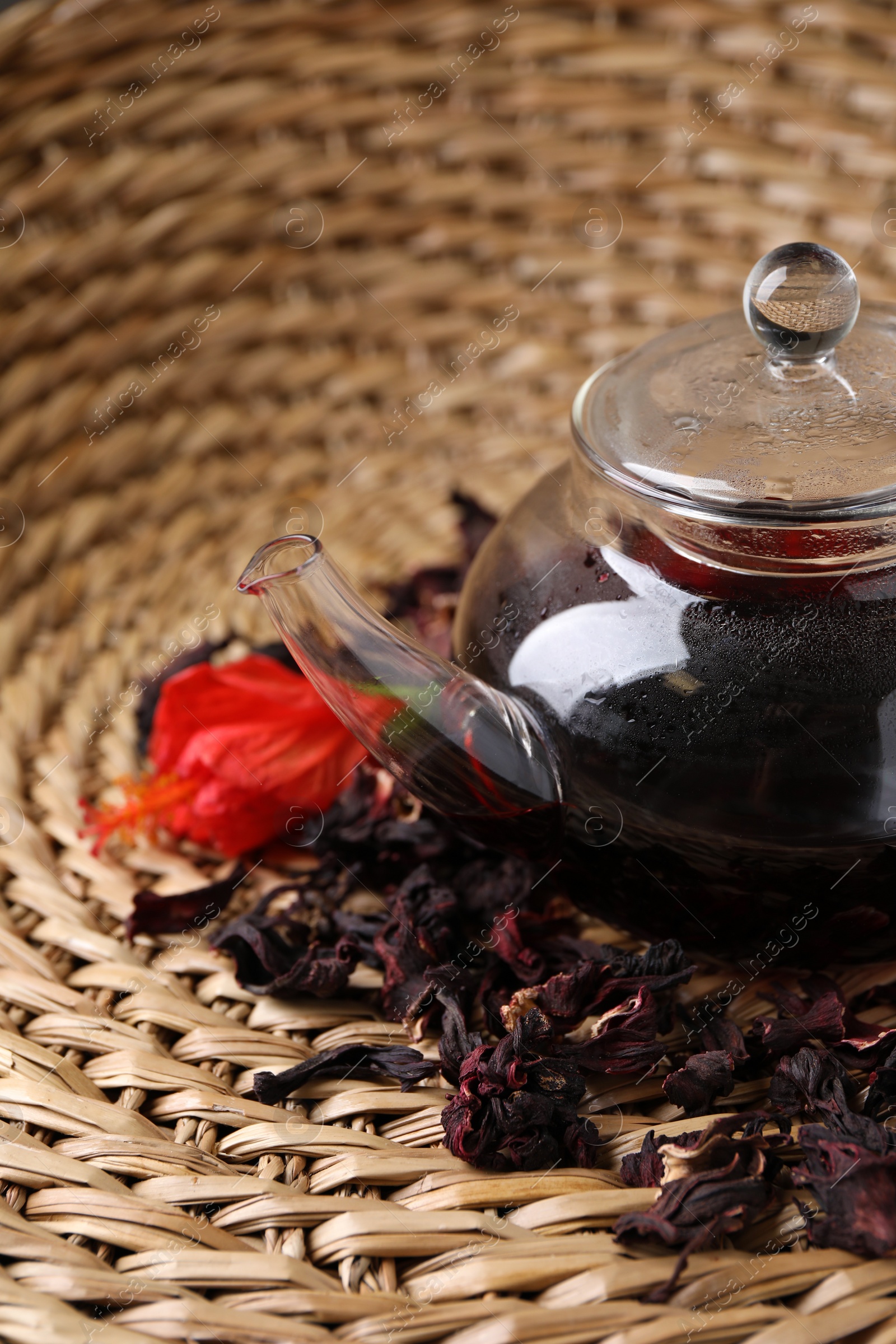 Photo of Freshly brewed hibiscus tea on wicker mat, closeup