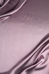 Photo of Crumpled dark purple silk fabric as background, top view. Space for text