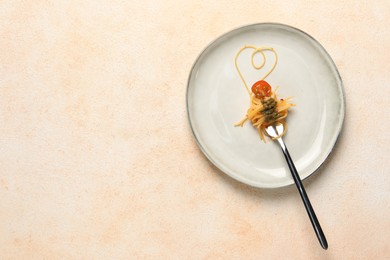 Photo of Heart made with spaghetti and fork on beige table, top view. Space for text