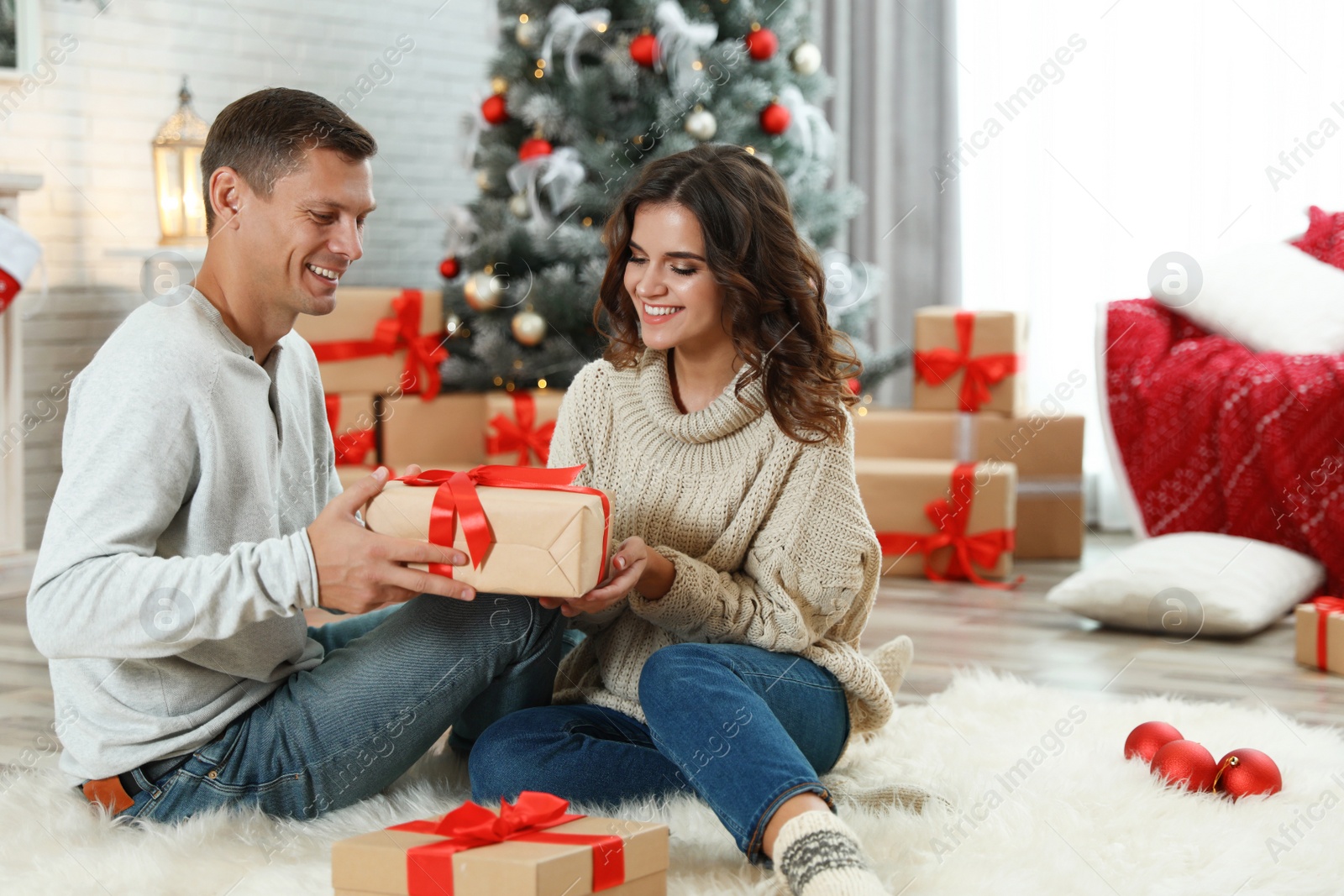 Image of Happy couple with Christmas gift at home