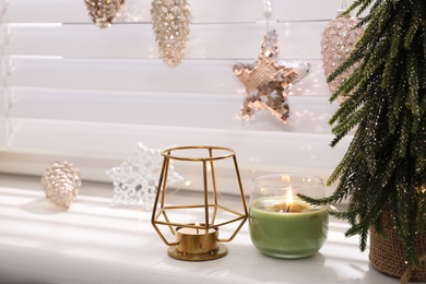 Photo of Beautiful candle holder and other Christmas decorations on window sill