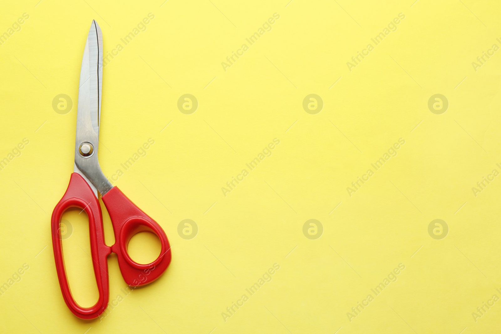 Photo of Pair of sharp scissors on color background, top view. Space for text