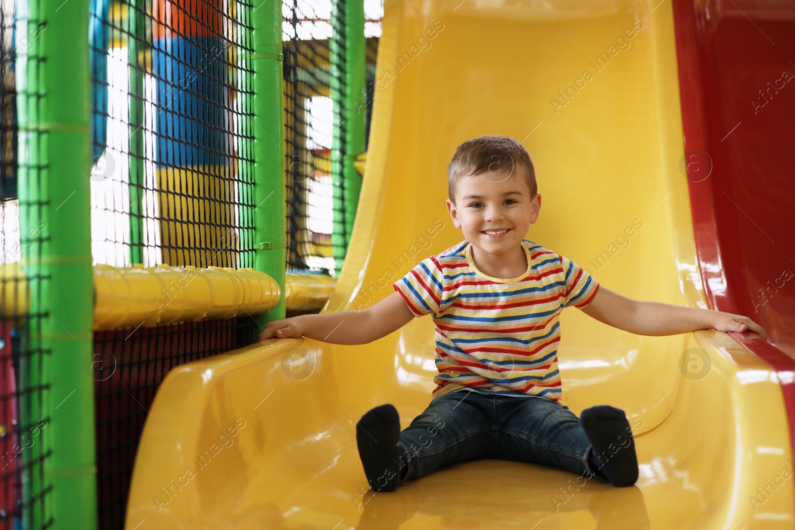 Photo of Cute little child playing at indoor amusement park