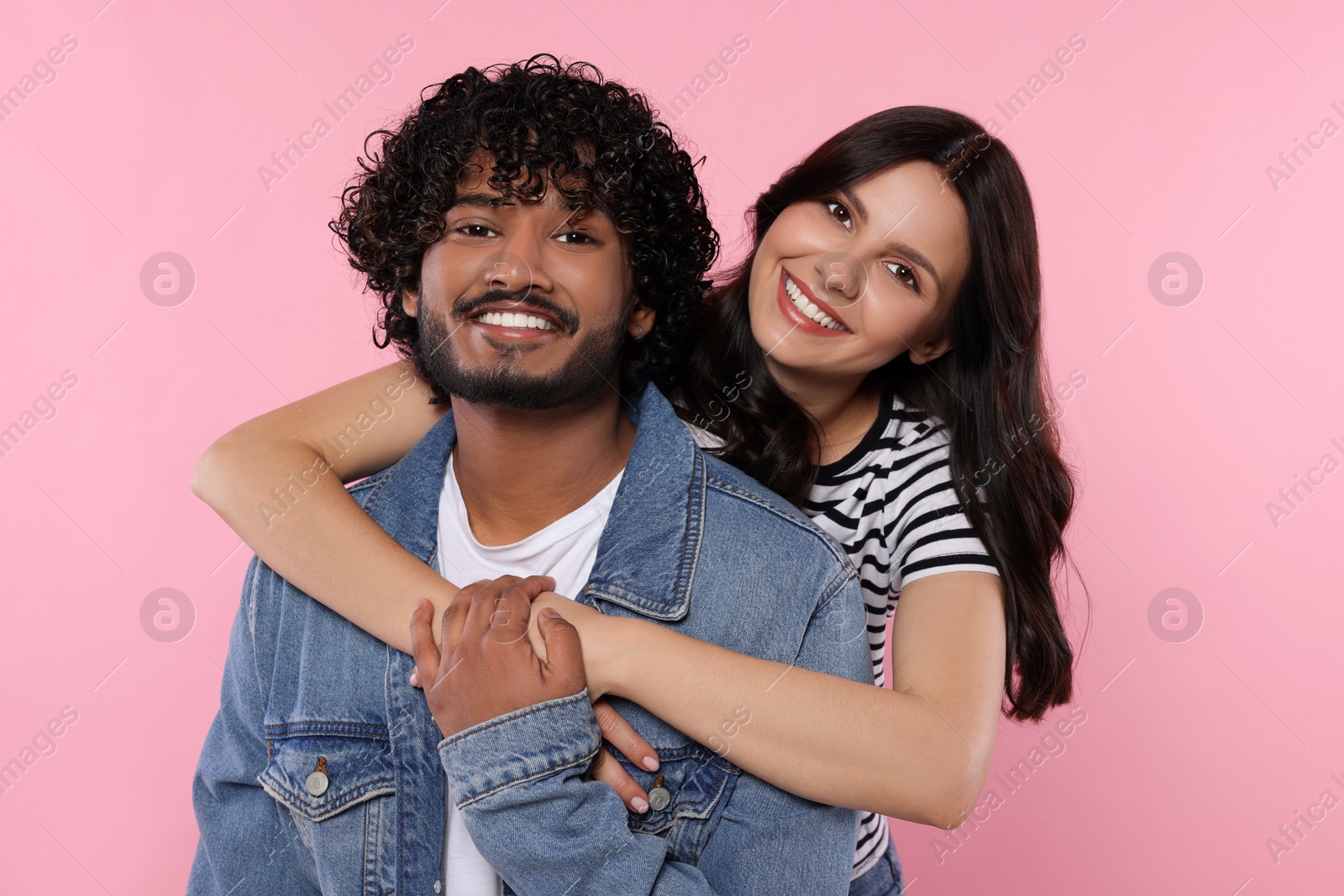 Photo of International dating. Happy couple hugging on pink background