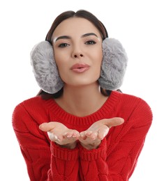 Beautiful young woman wearing earmuffs on white background