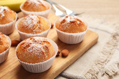Photo of Tasty muffins powdered with sugar on table, closeup