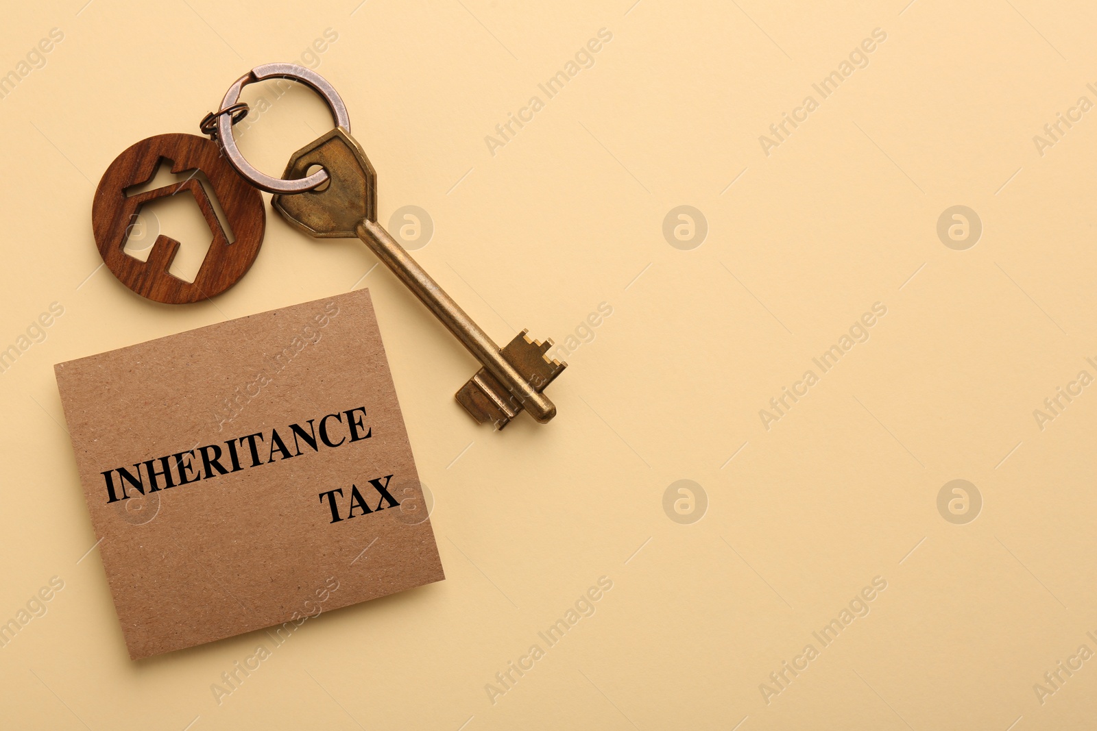 Photo of Inheritance Tax. Card and key with key chain in shape of house on beige background, top view. Space for text