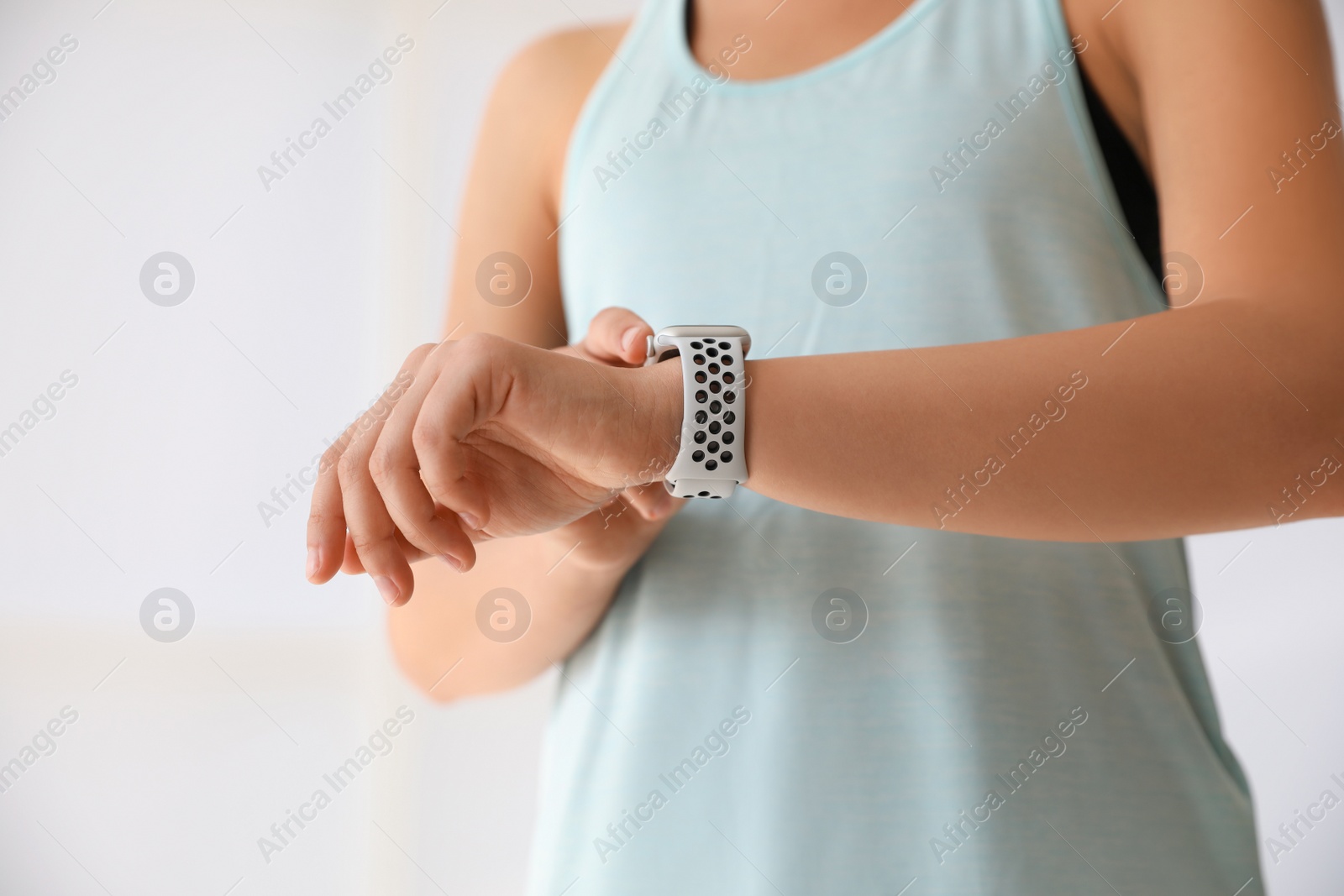 Photo of Woman checking fitness tracker indoors, closeup view