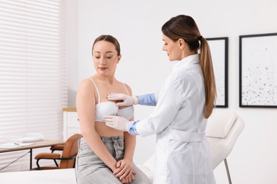 Mammologist checking young woman's breast in hospital