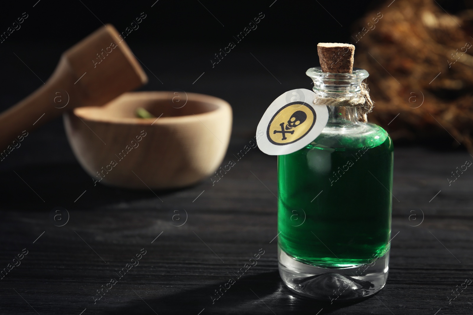 Photo of Bottle with poison on black wooden table. Space for text