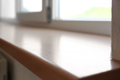 Photo of Closeup of plastic window with wooden sill