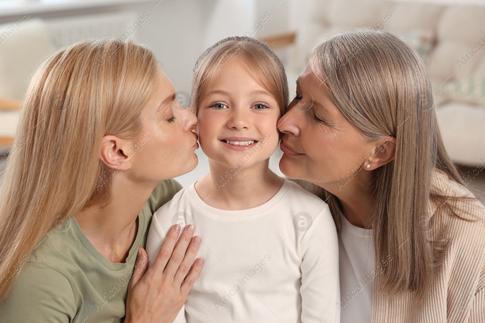 Photo of Three generations. Happy grandmother, her daughter and granddaughter at home