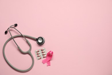 Breast cancer awareness. Pink ribbon, stethoscope and pills on color background, flat lay. Space for text