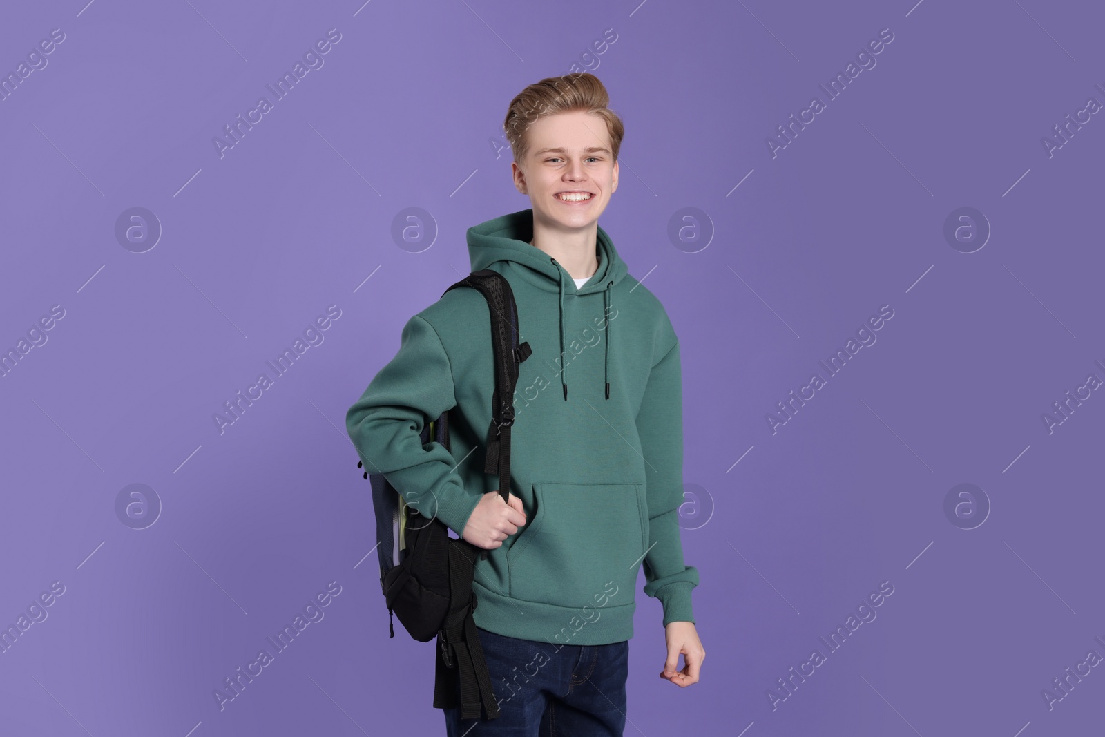 Photo of Teenage boy with backpack on purple background