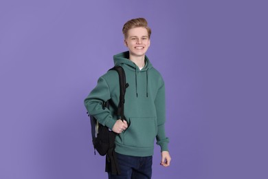 Photo of Teenage boy with backpack on purple background