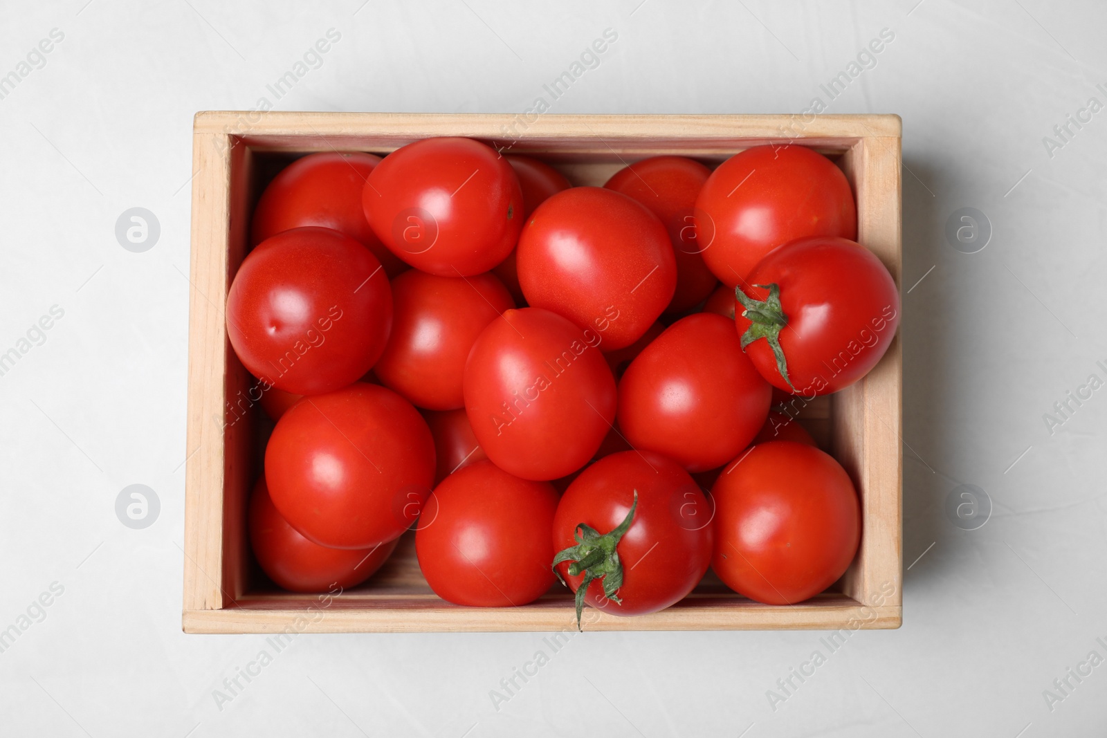 Photo of Wooden crate full of fresh delicious tomatoes on table, top view