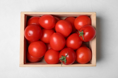 Photo of Wooden crate full of fresh delicious tomatoes on table, top view
