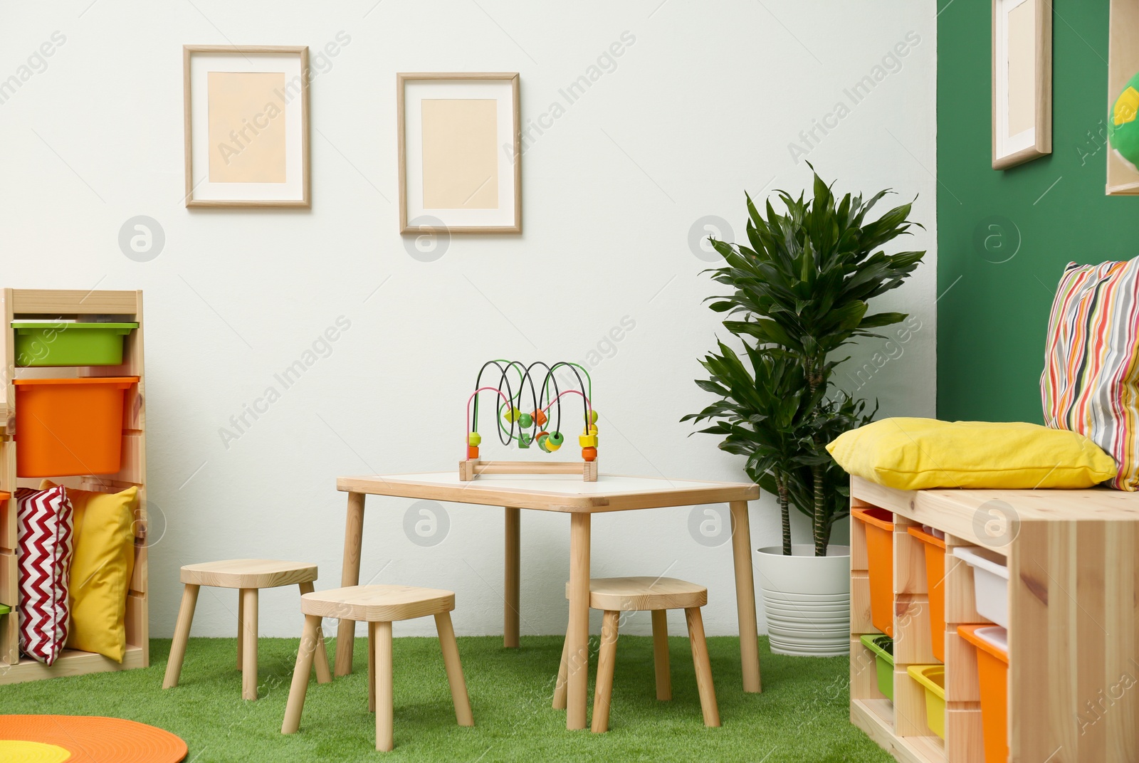 Photo of Stylish playroom interior with table and stools