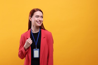 Photo of Smiling woman with vip pass badge on orange background, space for text