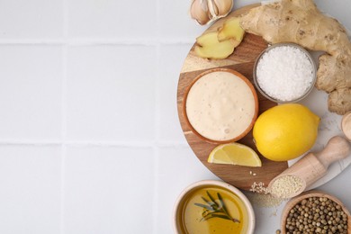 Photo of Flat lay composition with fresh marinade and different ingredients on white tiled table. Space for text