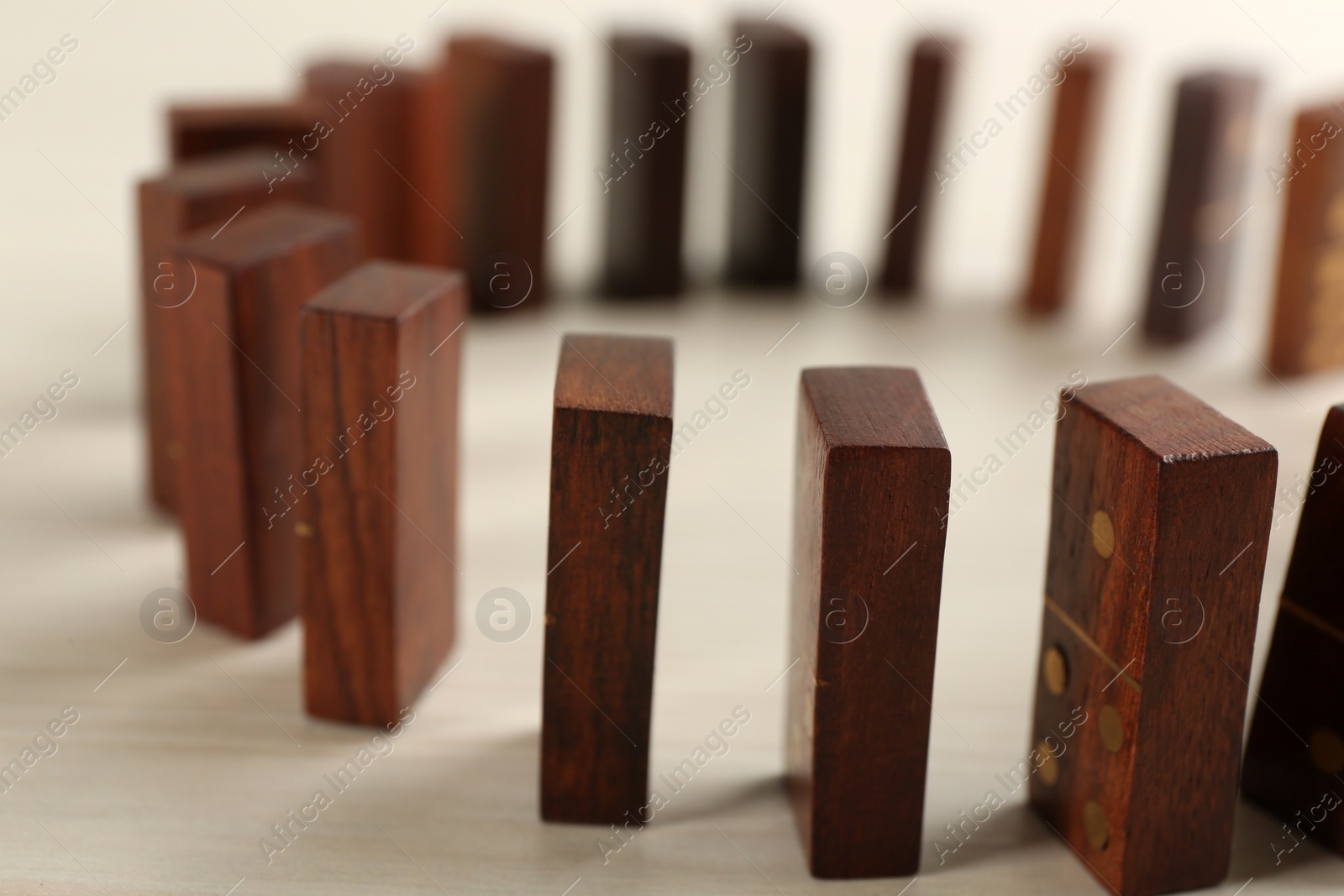 Photo of Wooden domino tiles on white table, closeup