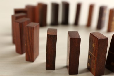 Wooden domino tiles on white table, closeup