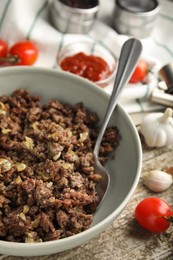 Fried minced meat and different products on wooden table, closeup