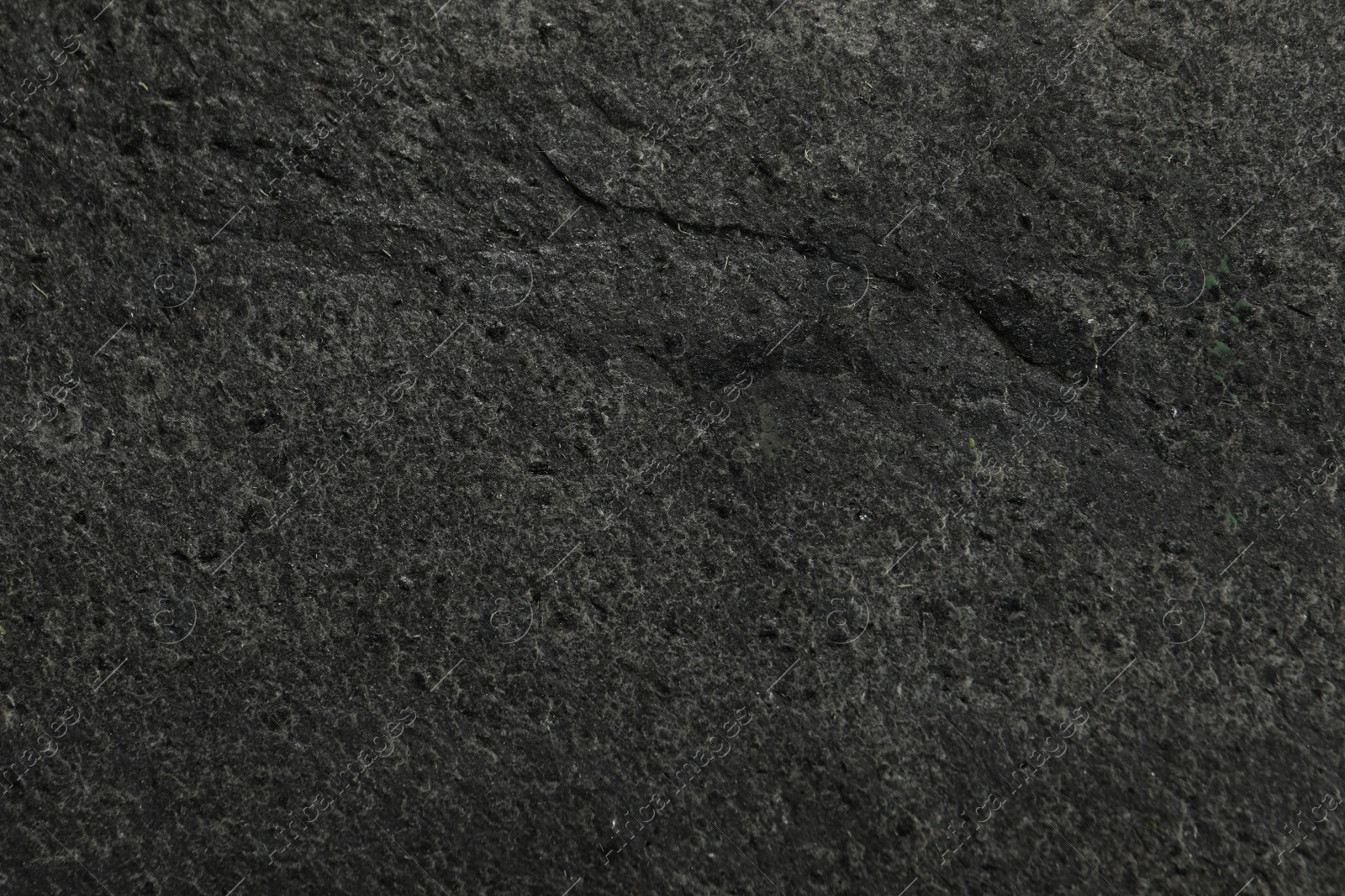 Photo of Texture of dark grey stone surface as background, closeup