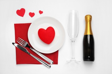 Photo of Beautiful table setting with sparkling wine for romantic dinner on white background, flat lay