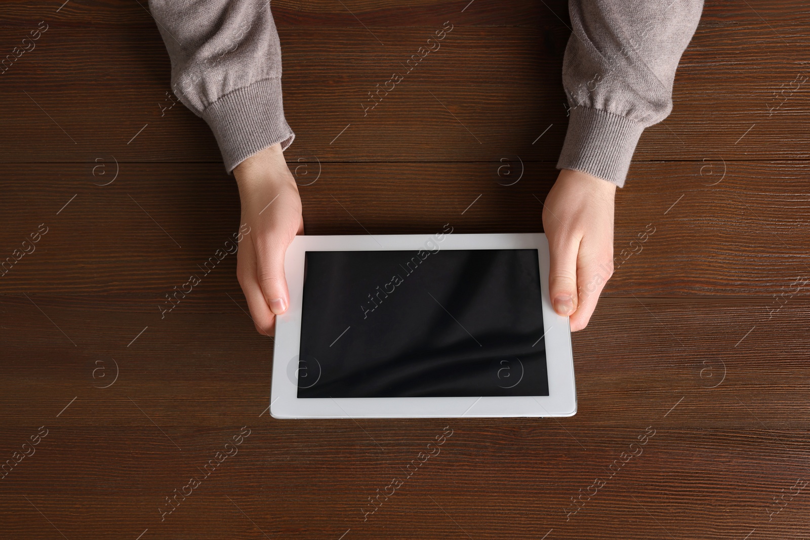 Photo of Man working with tablet at wooden table, top view