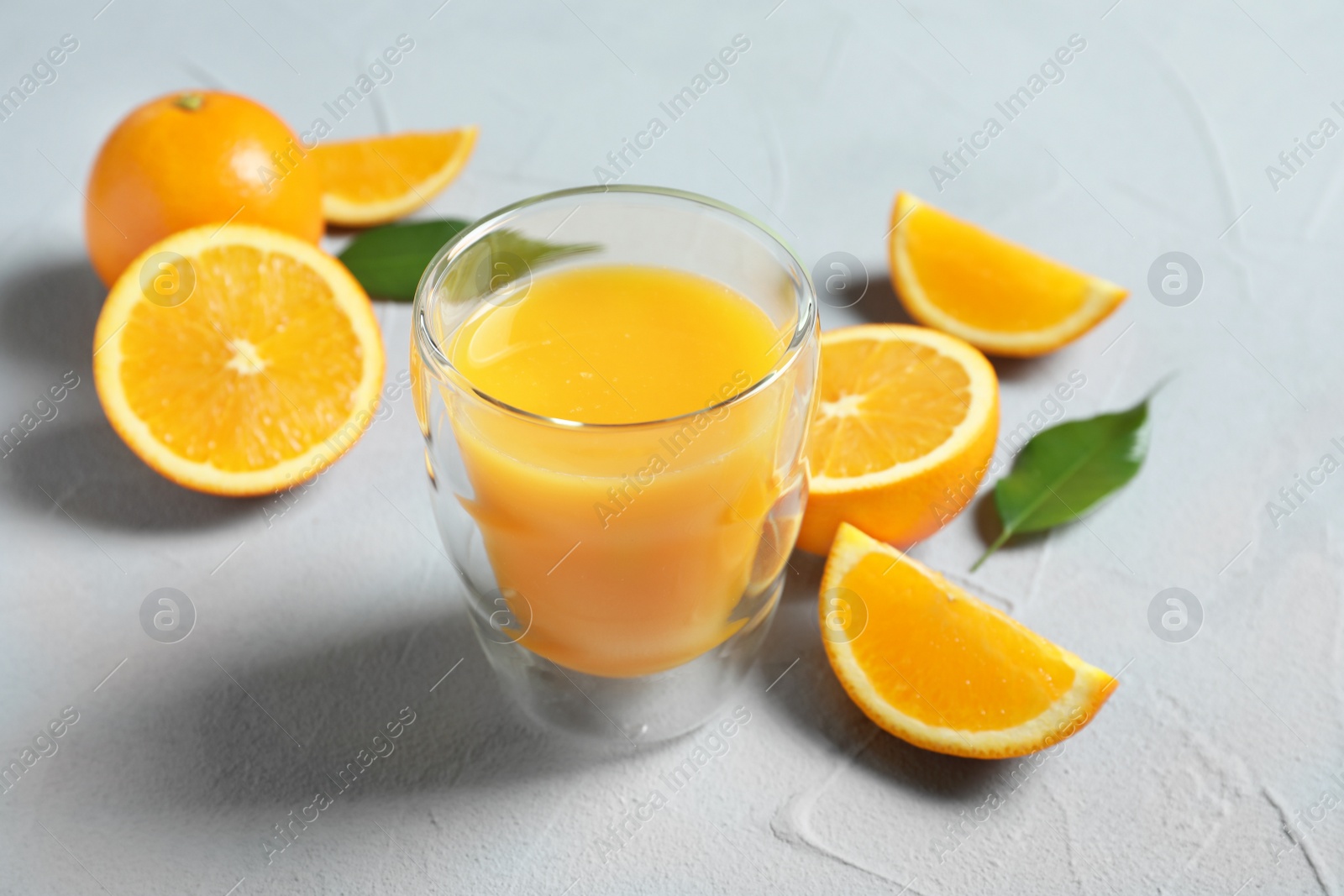 Photo of Glass of orange juice and fresh fruits on table