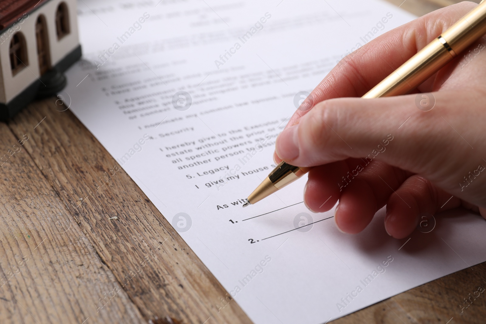 Photo of Woman signing Last Will and Testament at wooden table, closeup