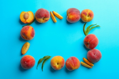 Flat lay composition with fresh peaches on blue background. Space for text