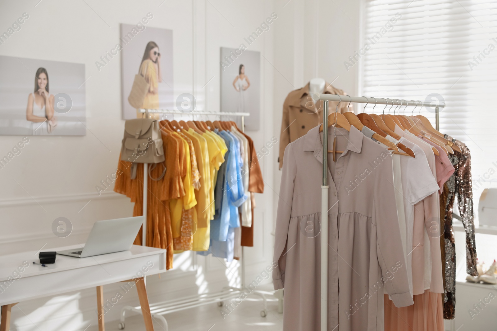 Photo of Modern boutique interior with stylish clothes and laptop