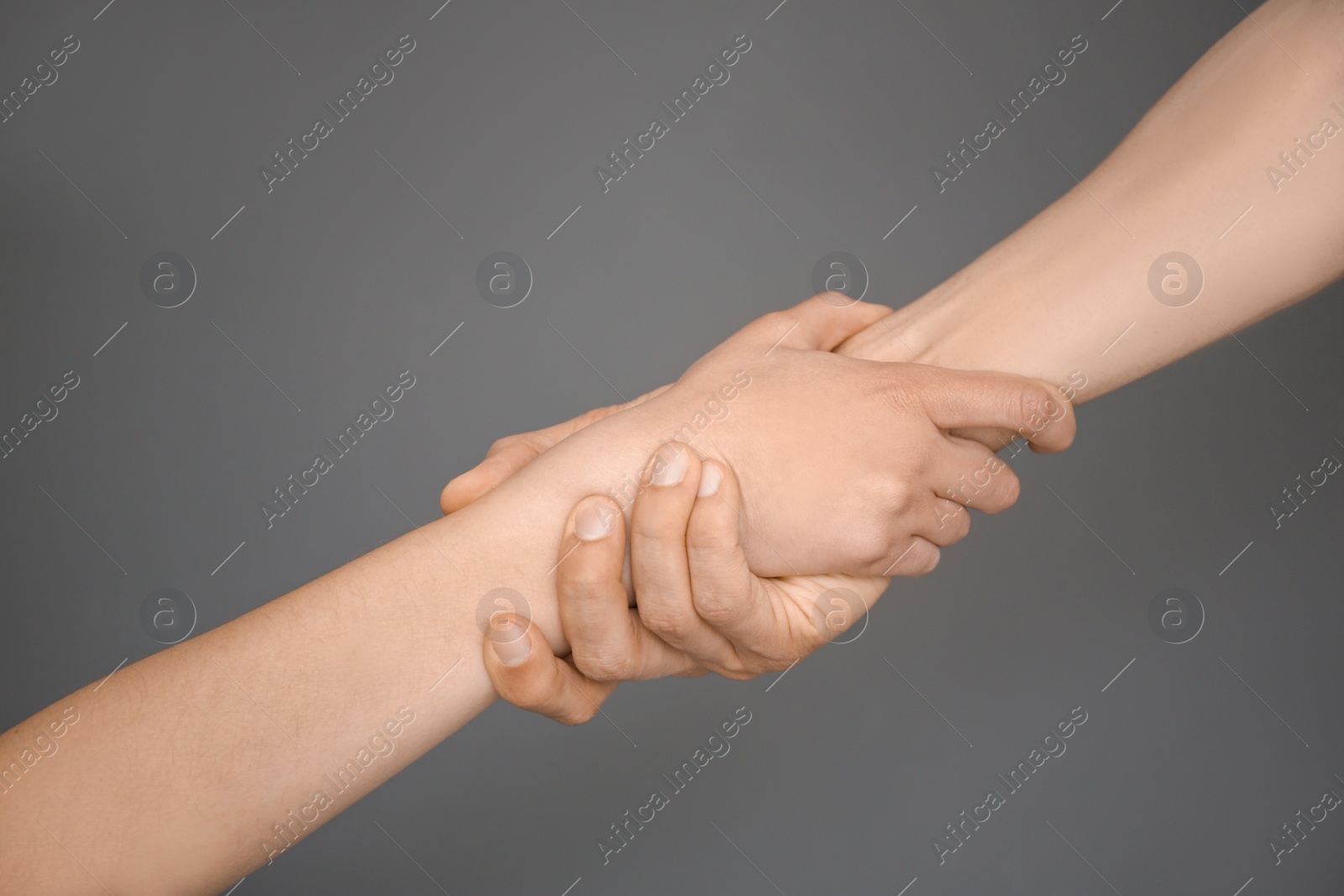 Photo of Man and woman holding hands together on grey background. Unity concept