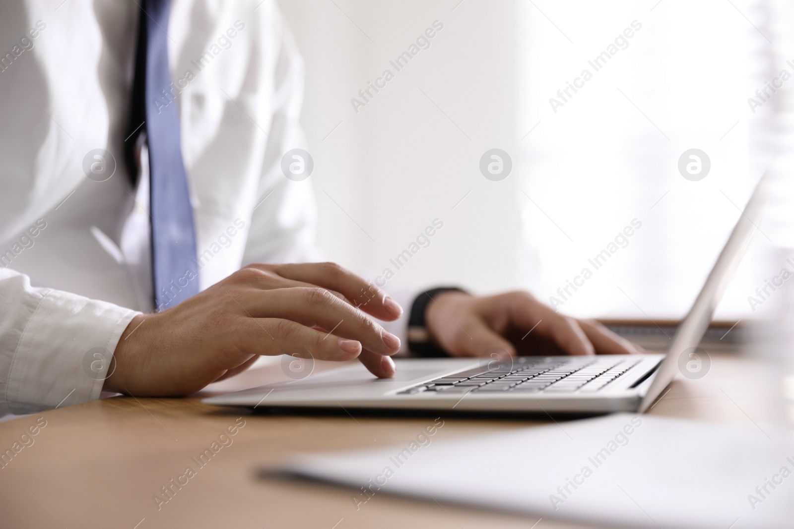 Photo of Man working with laptop in office, closeup of hand