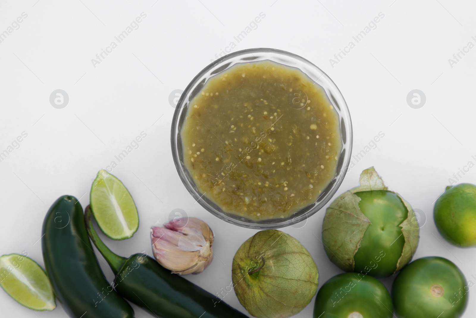 Photo of Tasty salsa sauce and ingredients on white background, top view