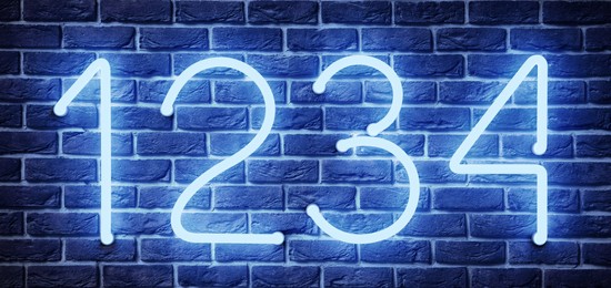 Image of Glowing neon number (1, 2, 3, 4) signs on brick wall