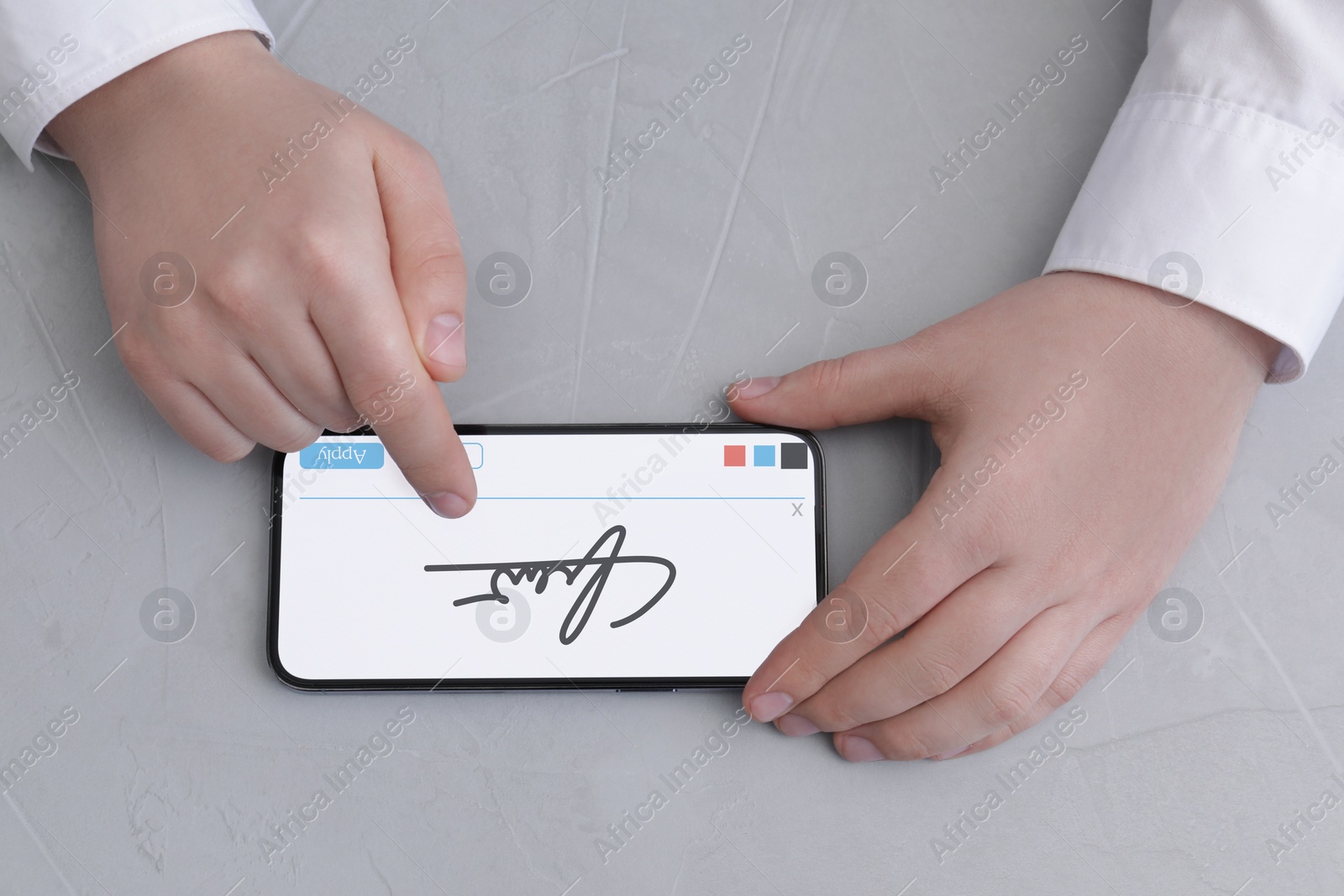 Image of Electronic signature. Man using mobile phone at grey table, top view