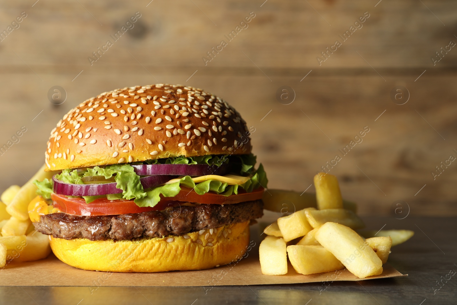 Burger with delicious patty and french fries on table, closeup Photo of Burger with delicious patty and french fries on table, closeup