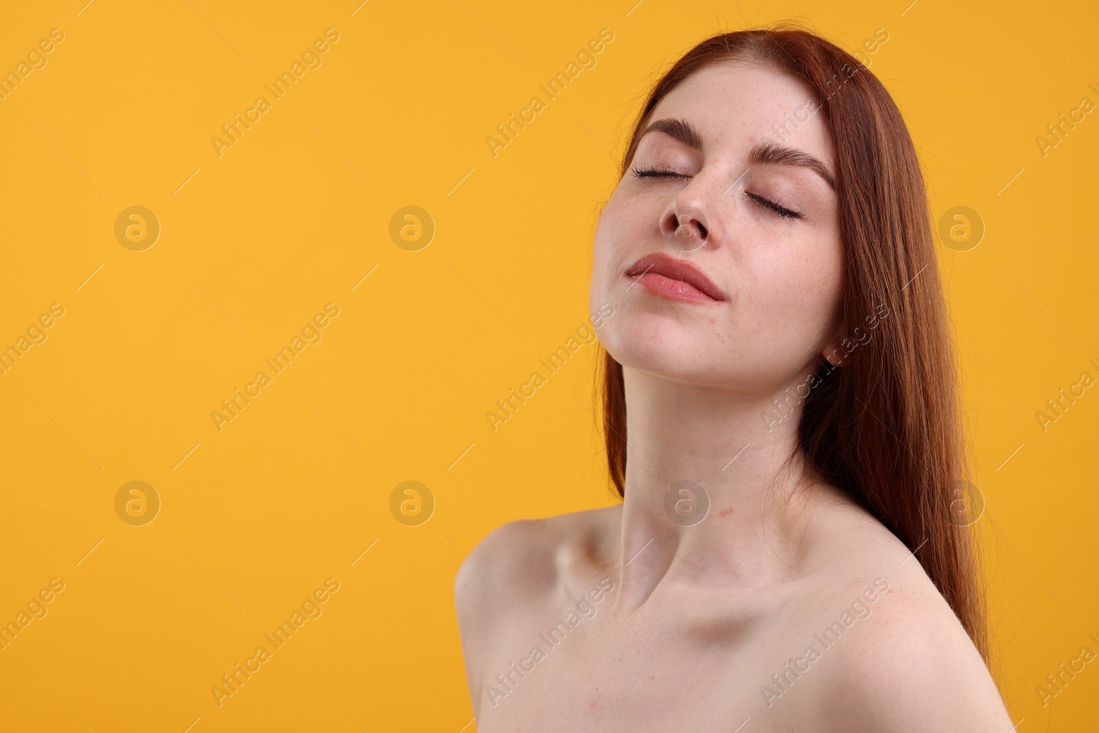 Photo of Portrait of beautiful woman with freckles on yellow background. Space for text