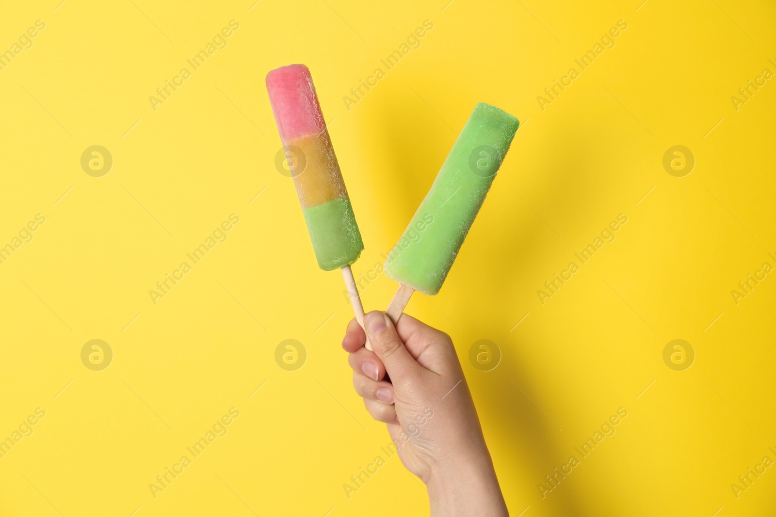 Photo of Woman holding delicious ice creams against color background