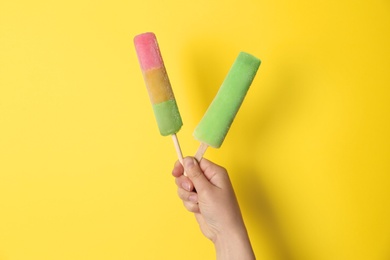 Photo of Woman holding delicious ice creams against color background